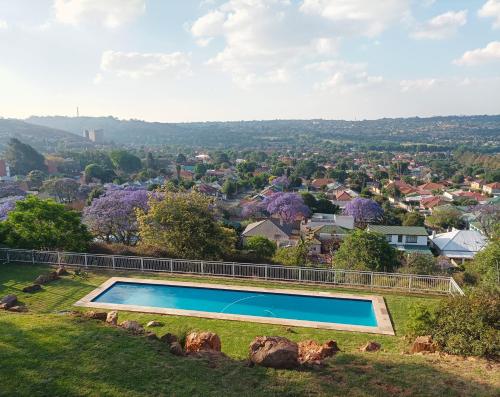 Johannesburg的住宿－Fishbird Art Deco Villa，一座位于山顶的游泳池,一座城市