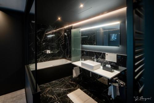 Baño con 2 lavabos y espejo en Les Thermes de Spa by La Cour de la Reine Hôtel, Suites & accès gratuit au centre thermal, en Spa