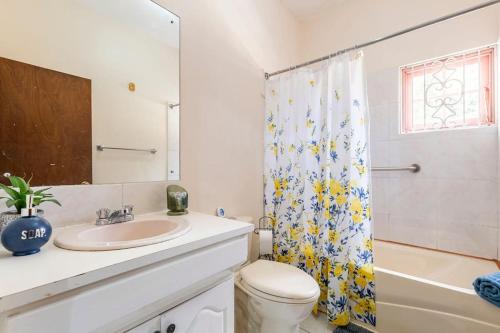 a bathroom with a sink and a shower curtain at Shaw Park Gem in Ocho Rios