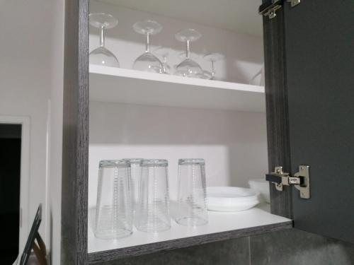 赫內的住宿－estrella24 LIVING ROOMS Chita，装满玻璃杯和碗的架子