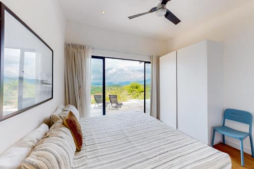 Schlafzimmer mit einem Bett und einer Glasschiebetür in der Unterkunft Casa Vista Mar in Puerto Viejo