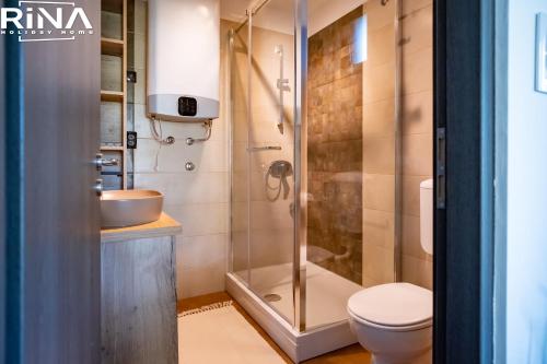 a bathroom with a shower with a toilet and a sink at Kuća za odmor Rina in Pakrac