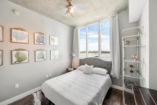 een witte slaapkamer met een bed en een raam bij The Edge in West Palm Beach