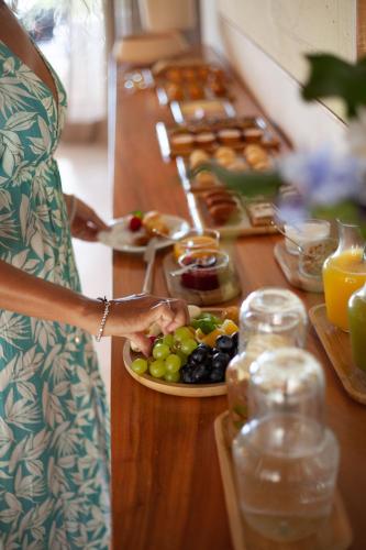 een vrouw met een bord fruit op een tafel bij Casa Siará Preá in Prea