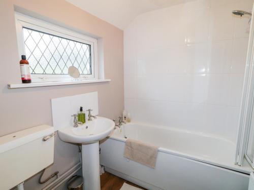 łazienka z umywalką, wanną i toaletą w obiekcie Rose Cottage w mieście Omagh