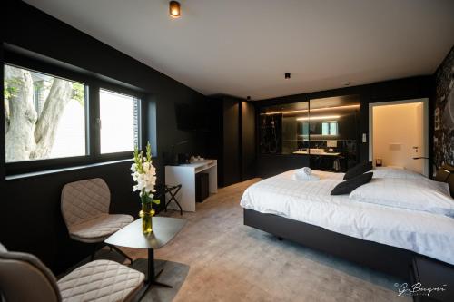 1 dormitorio con 1 cama, 1 mesa y 1 silla en Les Thermes de Spa by La Cour de la Reine Hôtel, Suites & accès gratuit au centre thermal, en Spa