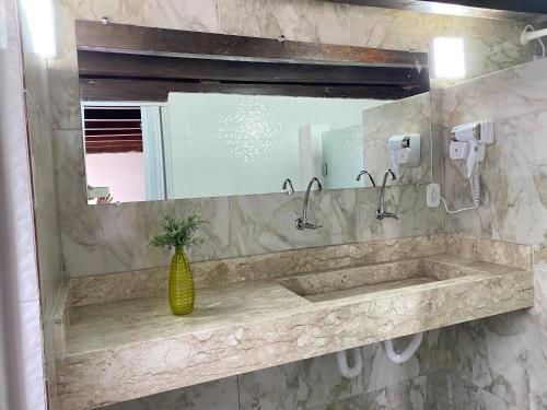 a bathroom with a sink and a mirror at Pousada Tropicália in Arraial d'Ajuda