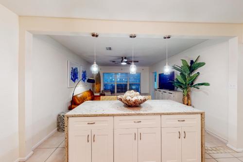 a kitchen with a white island in a room at Turquoise Breezes A in Cocoa Beach