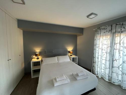 een slaapkamer met een wit bed en 2 handdoeken bij IV Apartamento junto a PLAZA MAYOR in Salamanca