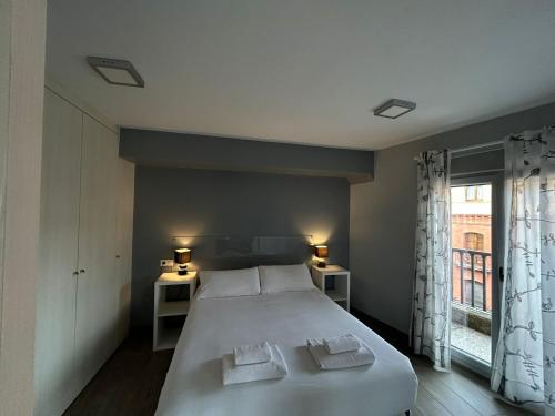 een slaapkamer met een groot bed en een raam bij IV Apartamento junto a PLAZA MAYOR in Salamanca