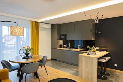 a kitchen and dining room with a table and chairs at Apartamenty STUDIO in Busko-Zdrój