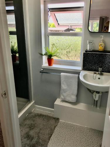 a bathroom with a sink and a window at Home from Home in our Self-Contained Annexe in Radwinter