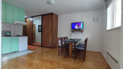 een keuken en eetkamer met een tafel en stoelen bij Ski lift apartman dm Brzeće in Brzeće