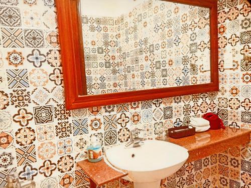 a bathroom with a sink and a mirror at Hue Pink Lotus Hotel in Hue