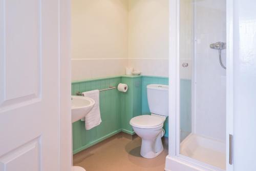 a bathroom with a toilet and a sink at Cosy room with golf & the beach on your doorstep! in Mawgan Porth