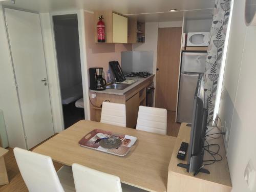 a small kitchen with a table with a television on it at Mobil-home in Valras-Plage