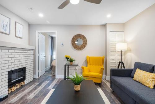 a living room with a blue couch and a yellow chair at Horizon - Mins to Las Olas & Beach in Hammocks