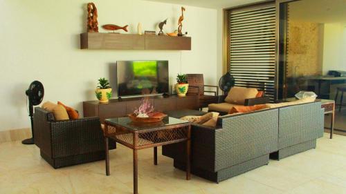 a living room with two couches and a tv at Donoussa Beach home in Uaymitun