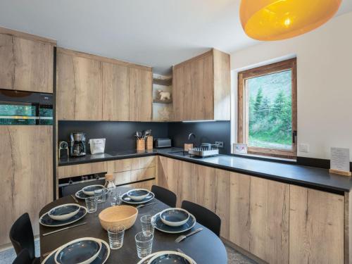 une salle à manger avec une table et des chaises dans une cuisine dans l'établissement Appartement familial skis aux pieds à Courchevel - 6 personnes, confort moderne - FR-1-563-109, à Courchevel
