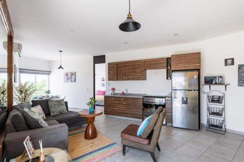 a living room with a couch and a kitchen at Primer Piso condo , 3 Recamaras+2.5 baños +alberca in Cabo San Lucas