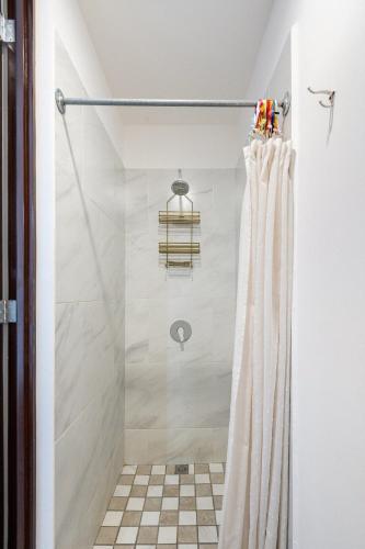 a shower with a shower curtain in a bathroom at Primer Piso condo , 3 Recamaras+2.5 baños +alberca in Cabo San Lucas