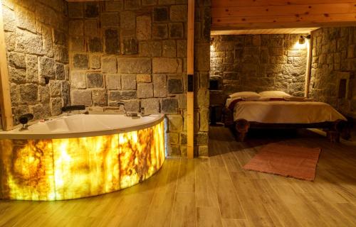 a bathroom with a tub in a room with a bed at Hobbit Chalet in Çamlıhemşin