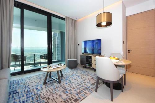 a living room with a table and a television at 1 BEDROOM ADDRESS BEACH FRONT JBR in Dubai