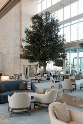 a lobby with couches and chairs and a tree at 1 BEDROOM ADDRESS BEACH FRONT JBR in Dubai