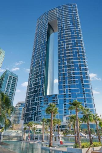 a tall building with palm trees in front of it at 1 BEDROOM ADDRESS BEACH FRONT JBR in Dubai