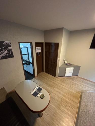 ein Wohnzimmer mit einem Tisch und einem Schreibtisch in der Unterkunft Motel Ibiza in Pará de Minas