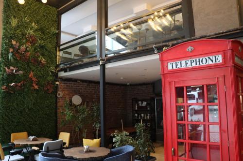 an old red phone booth in front of a restaurant at Dab Hotel Ulus in Ankara