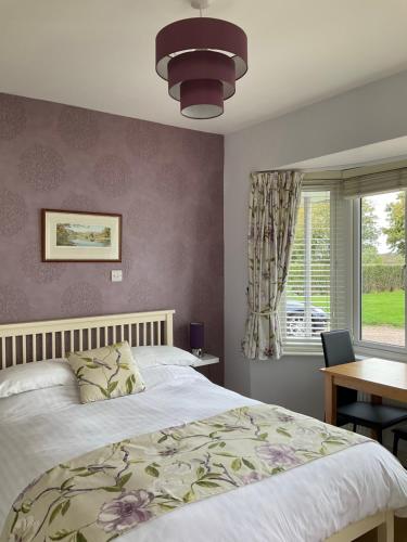 a bedroom with a bed and a table and a window at Wilmcote Bed and Breakfast in Wilmcote