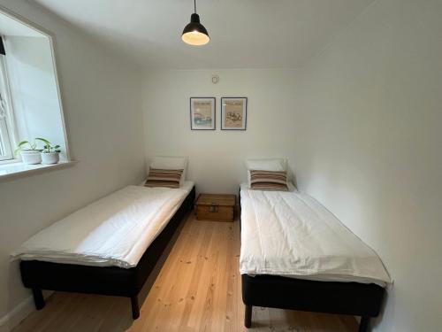 two twin beds in a room with a window at Strandby 1847 B&B in Nykøbing Falster