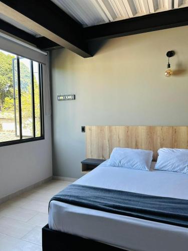 a bedroom with a bed and a window at Seven hotel in Santa Fe de Antioquia