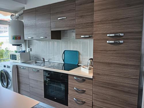 a kitchen with wooden cabinets and a blue chair at Sunny holidays in Santa Pola in Santa Pola
