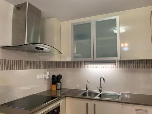 a kitchen with white cabinets and a sink at Boutique Granny Flat in Paraparap