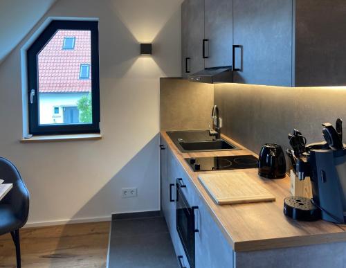 a kitchen with a counter and a sink and a window at Filder-Appartements in Filderstadt
