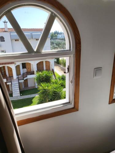 an arched window with a view of a courtyard at Sunflower maisonette with attic in Loutraki