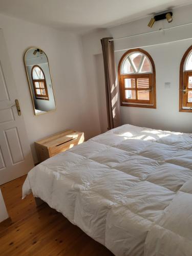 a bedroom with a white bed and a mirror at Sunflower maisonette with attic in Loutraki