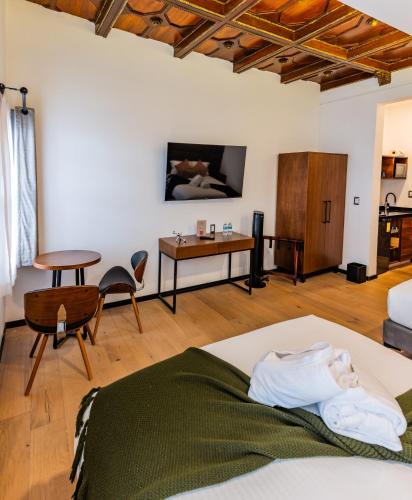 a bedroom with a bed and a table and chairs at Casa Castillo in Mexico City