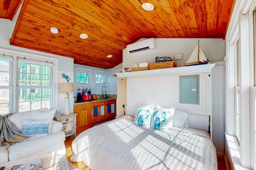 a bedroom with a white bed and a wooden ceiling at The Atlantic in Yarmouth