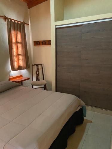 - une chambre avec un lit et une porte coulissante dans l'établissement Cabañas La Suyana, à Tafí del Valle