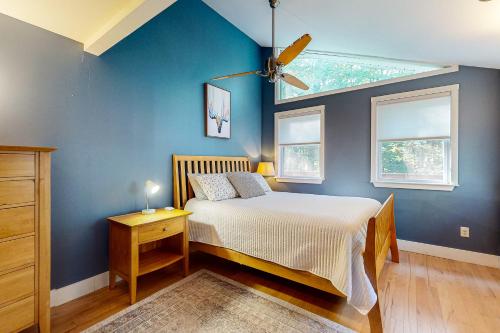 a bedroom with a bed and a blue wall at Camp Crooked in Naples
