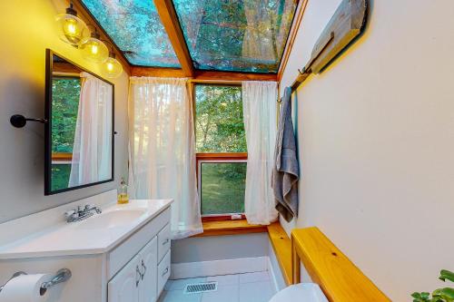 a bathroom with a sink and two windows at Camp Crooked in Naples