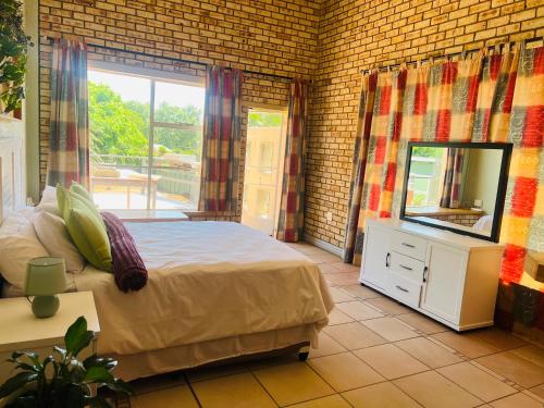 a bedroom with a bed and a mirror at Langerman Lookout: Inviting Home with Rustic Charm and Modern Comfort in Johannesburg