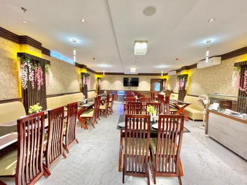 um restaurante com cadeiras e mesas de madeira numa sala em Hotel AMBIKA PALACE PURI em Puri