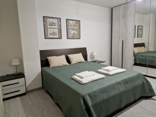 聖切薩雷奧的住宿－Casa Vacanze MAMI home 2/5 pers.，一间卧室配有绿床和2条毛巾