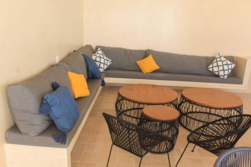 ein Wohnzimmer mit einem Sofa und 2 Tischen in der Unterkunft Luxury apartament 1 block to 5Th Avenue in Playa del Carmen