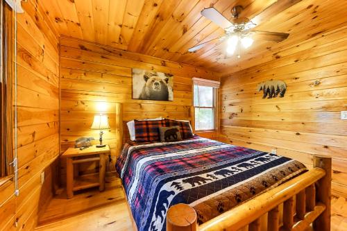 a bedroom with a bed in a log cabin at River's Creekside Cabin in Ellijay