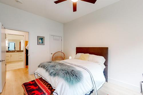 a bedroom with a white bed with a feather blanket on it at The Landing in Asheville